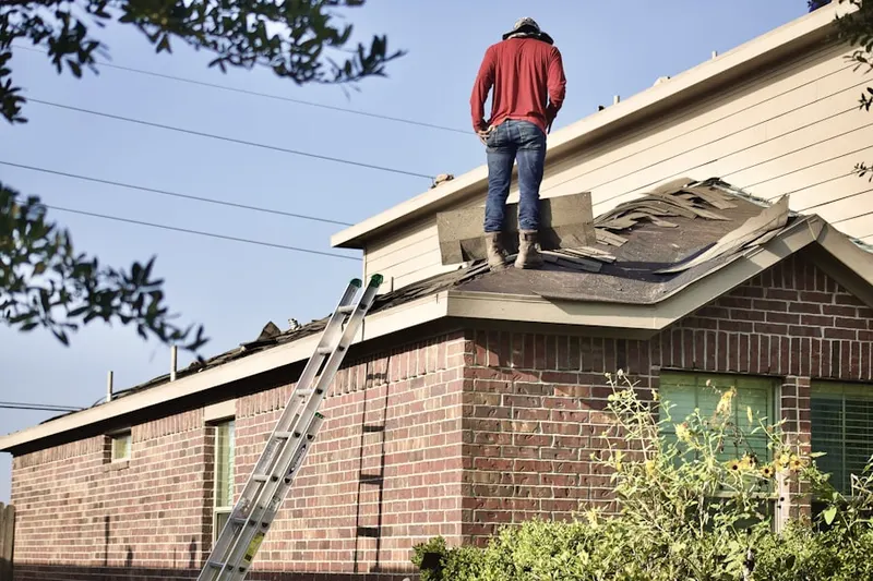 Professional roofer working on a residential roof in Vinton